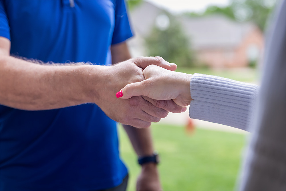 A Bell employee shaking a customer's hand.